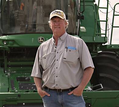 Client of Conner, Marr & Pinski standing in front of a green tractor.